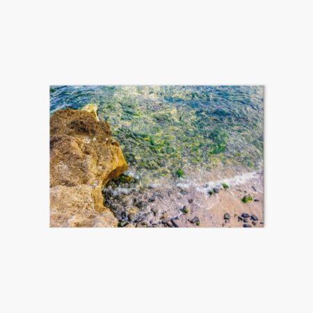 wave rolls onto the rocks of sandy coast Art Board Print