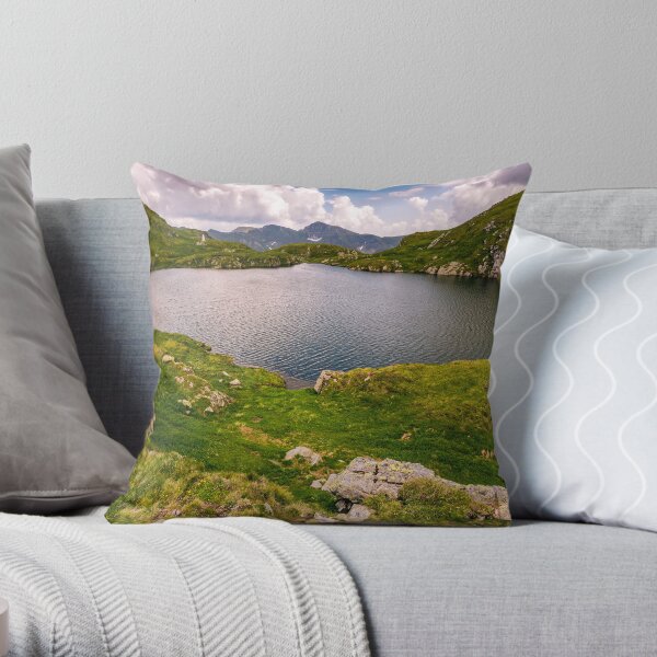 lake in mountains with grass on hillside Throw Pillow