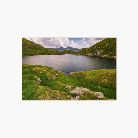 lake in mountains with grass on hillside Art Board Print