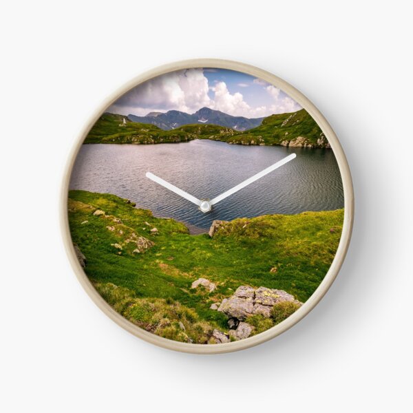 lake in mountains with grass on hillside Clock