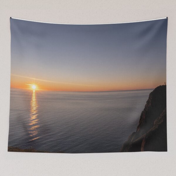 Item preview, Wonderful landscapes in Norway. Nord-Norge. Beautiful scenery of a midnight sun sunset at Nordkapp (Cape North). Boat and globe on a cliff. Rippled sea and clear orange sky.  designed and sold by Maurizio Fabbroni.