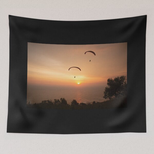 Item preview, Paragliding over the ocean and treetops while golden sunset designed and sold by kall3bu.