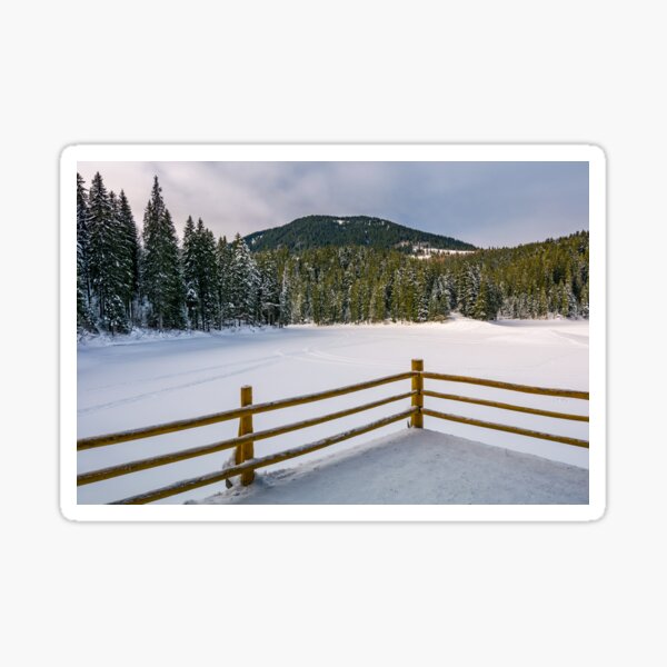 pier on snow covered forest lake in mountains Sticker