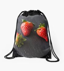 Three strawberries on a slate plate. Drawstring Bag