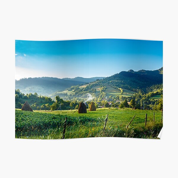 field with haystack on hillside in mountains Poster