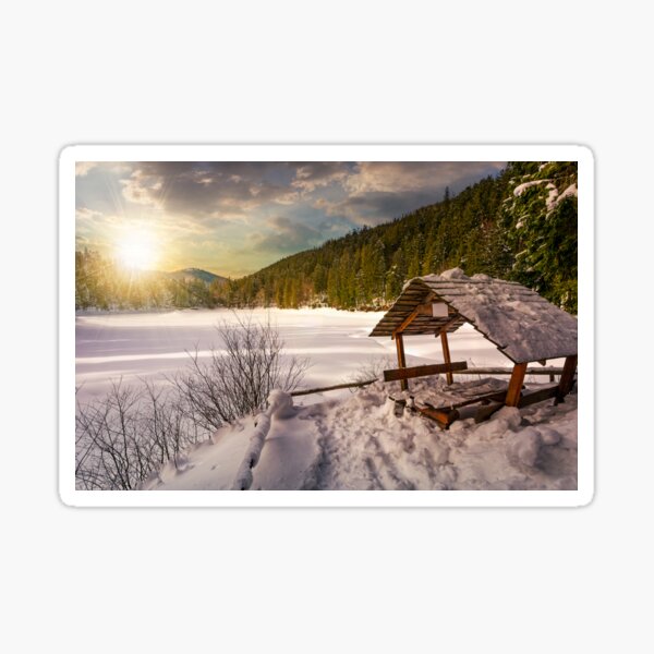 wooden bower in snowy winter forest at sunset Sticker