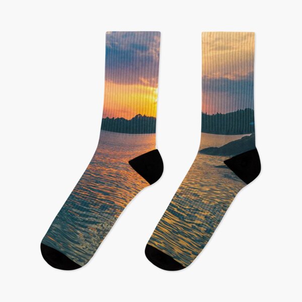 Item preview, Golden sunset over a coastline with orange sunlight on a calm sea. designed and sold by claireseyeview.