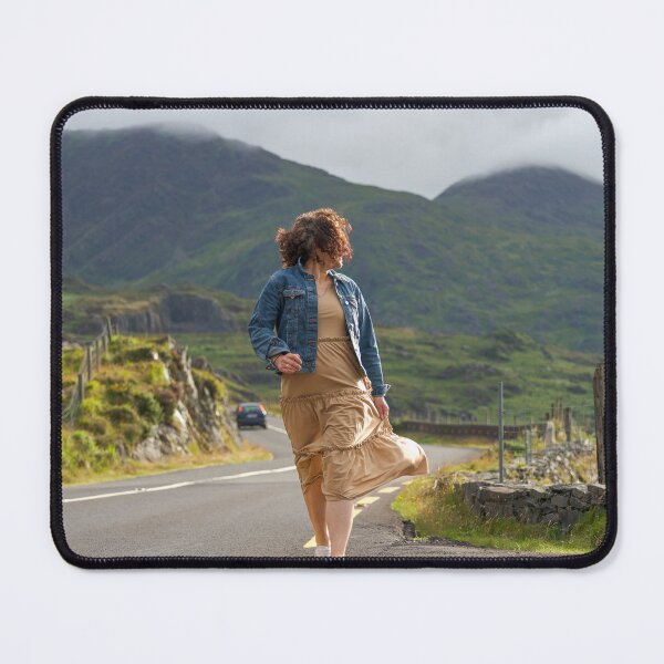 Item preview, A happy young woman wearing a dress and a blue denim jacket running along a road in Killarney National Park, Ring of Kerry, near the town of Killarney in County Kerry, Ireland. designed and sold by AlbertMi.