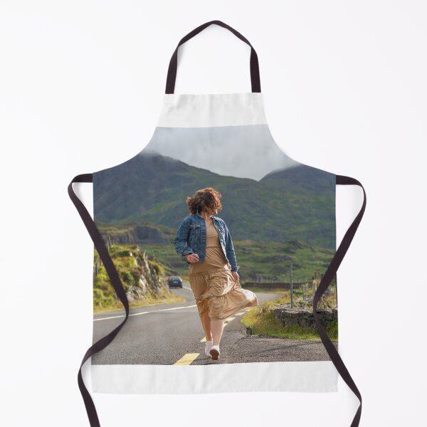 Item preview, A happy young woman wearing a dress and a blue denim jacket running along a road in Killarney National Park, Ring of Kerry, near the town of Killarney in County Kerry, Ireland. designed and sold by AlbertMi.