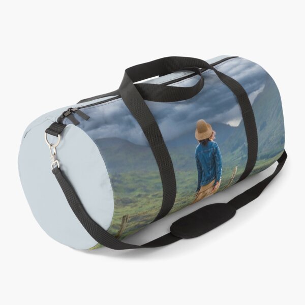Item preview, Young woman in a dress and straw hat enjoys the unforgettable views of Killarney National Park, the dramatic skies and green mountains of the Ring of Kerry near the town of Killarney in County Kerry, designed and sold by AlbertMi.
