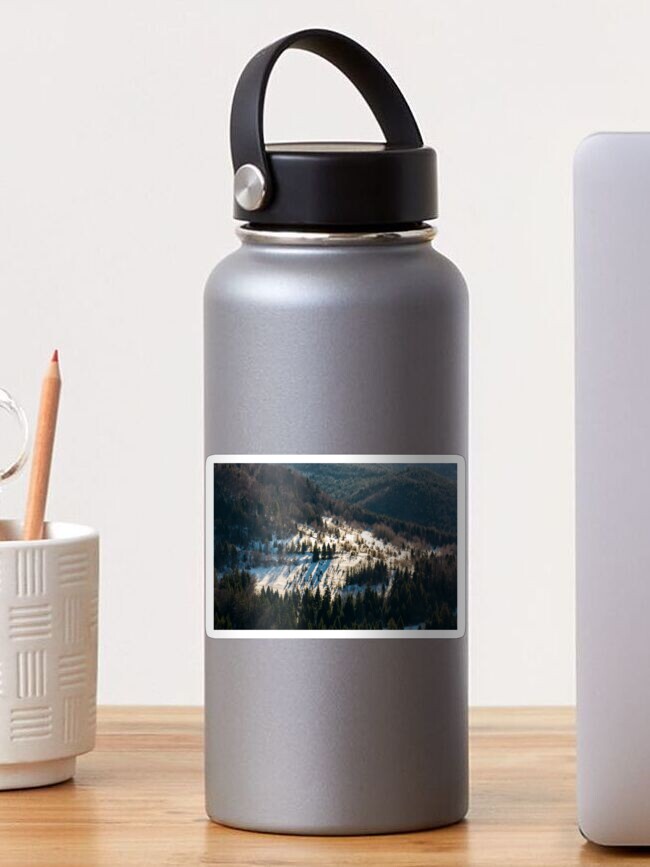 Thumbnail 1 of 3, Sticker, snow covered meadow among forest on hillside designed and sold by mike-pellinni.
