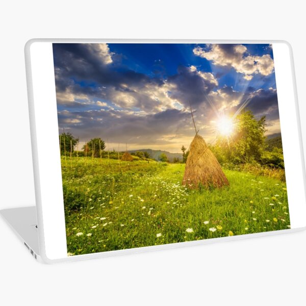 field with haystacks on hillside at sunset Laptop Skin