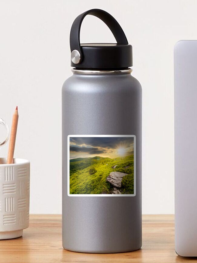 Thumbnail 1 of 3, Sticker, stones in valley on top of mountain range at sunset designed and sold by mike-pellinni.