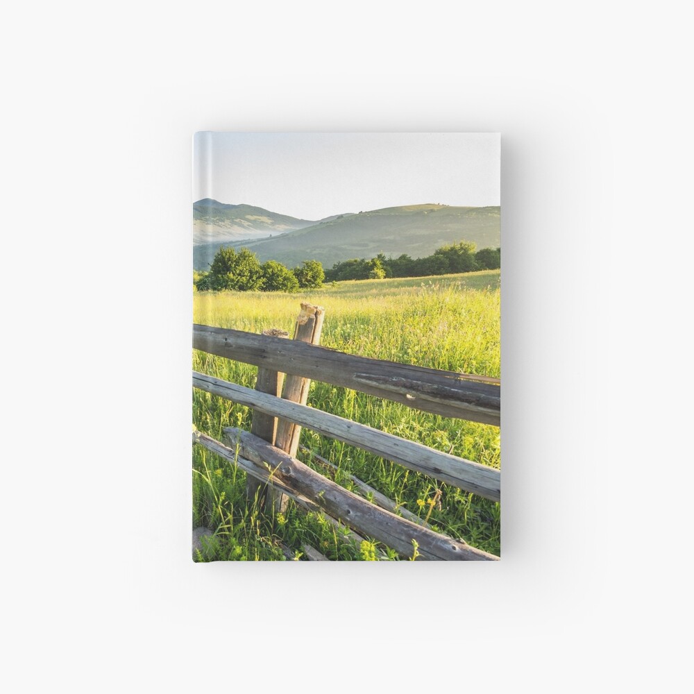 fence on hillside meadow in mountain Hardcover Journal