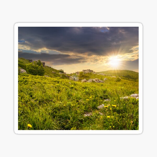 stones in valley on hillside at sunset Sticker