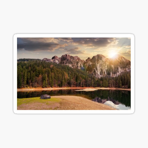 lake near the mountain in pine forest at sunset Sticker
