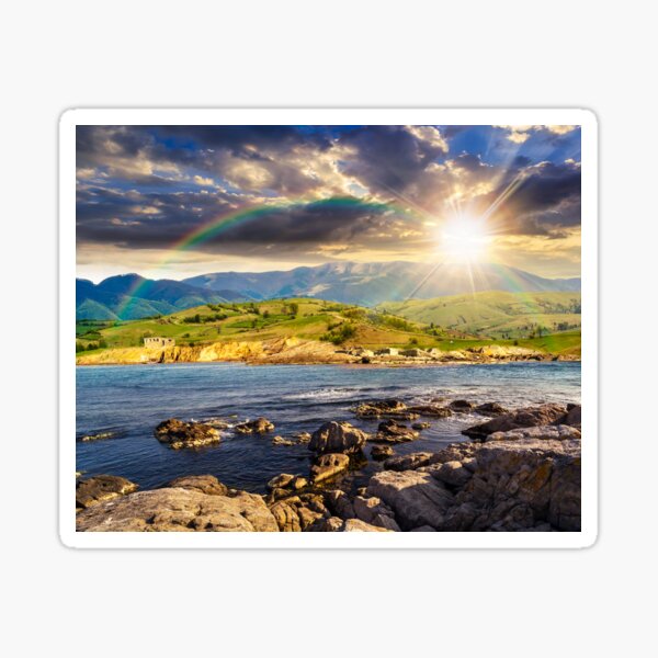 village near lake in mountains at sunset Sticker