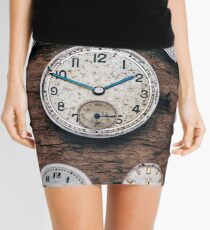 Tiny watch parts on a wooden background Mini Skirt