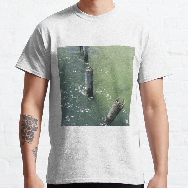 Old wooden piles sticking out of sea water Classic T-Shirt