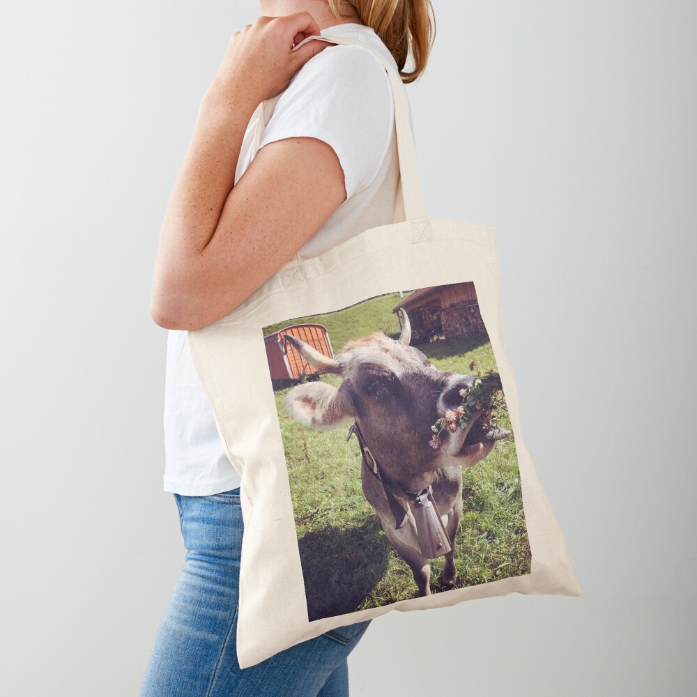 A Swiss cow enjoying herbs Tote Bag