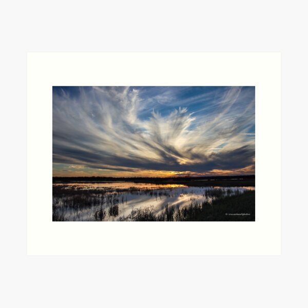 Dramatic clouds and reflection at sunset Art Print