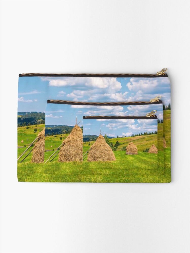 Alternate view of haystacks in a row on a grassy field Zipper Pouch