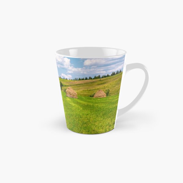haystacks in a row on a grassy field Tall Mug