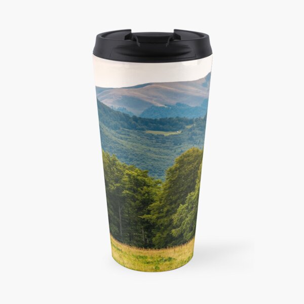 grassy meadow on forested hillside of Carpathians Travel Mug