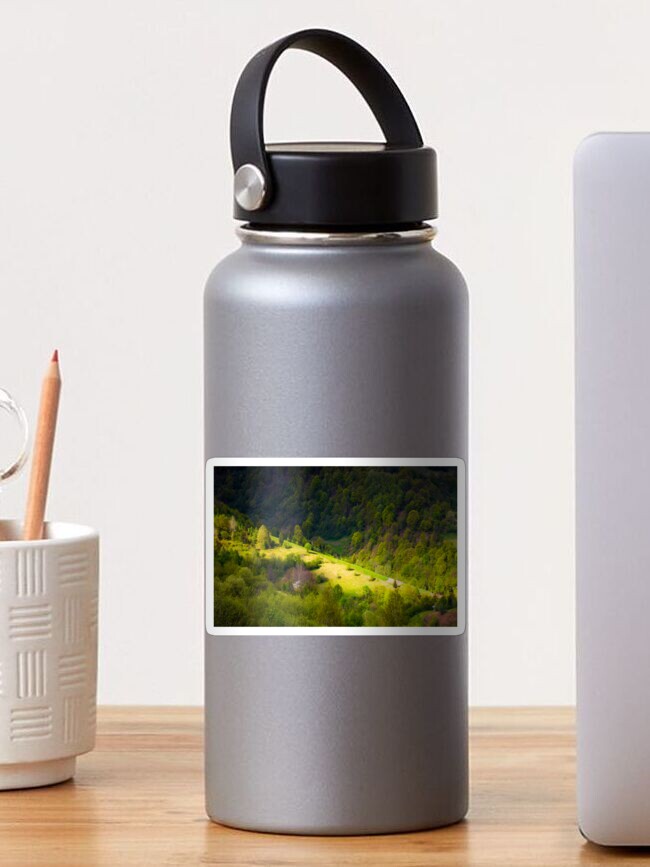 Thumbnail 1 of 3, Sticker, spot of light on forested hillside designed and sold by mike-pellinni.