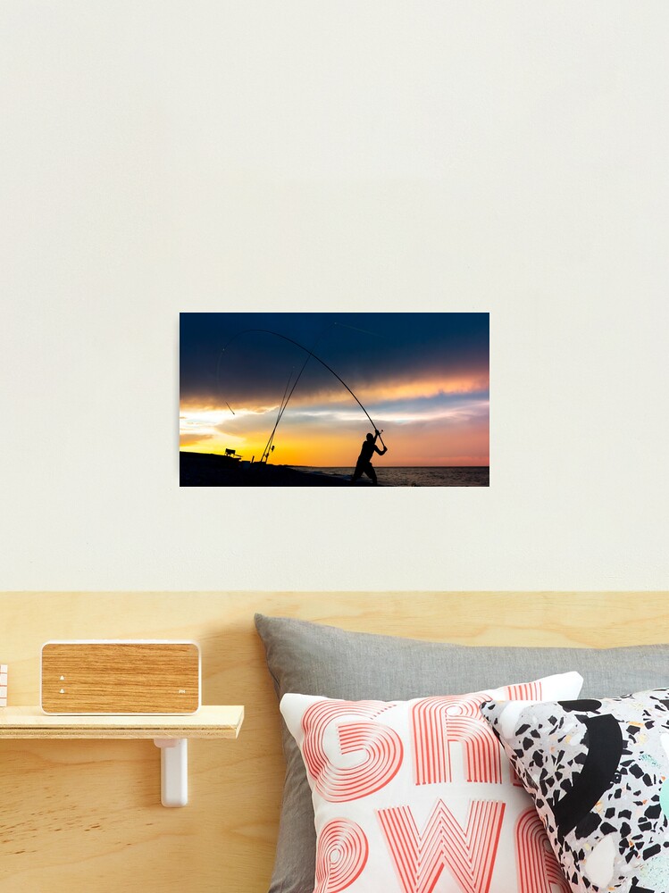 Fisherman cast fishing rods on the seashore at a dramatic sunset. |  Photographic Print