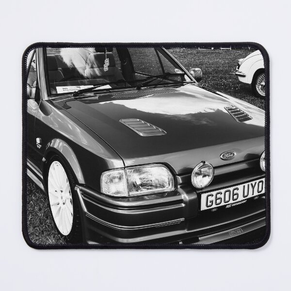 Item preview, Black and white image of the front of a blue Ford Escort convertible, 1990 designed and sold by Graham Cornall.