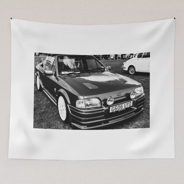 Item preview, Black and white image of the front of a blue Ford Escort convertible, 1990 designed and sold by Graham Cornall.