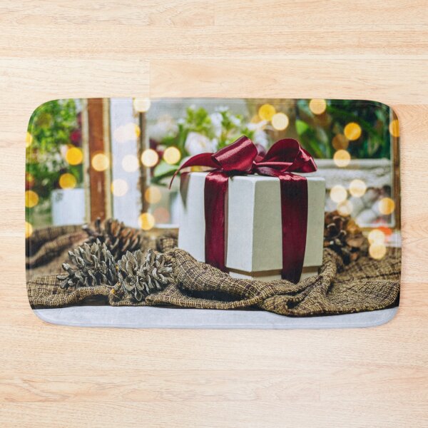 Item preview, christmas and new year background - gift box and pine cones near window show a garden and light bokeh designed and sold by sigoisette.