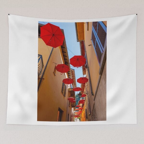 Item preview, City Street in Porto Ceresio with Hanging Umbrellas in a Sunny Summer Day designed and sold by Mats Silvan.