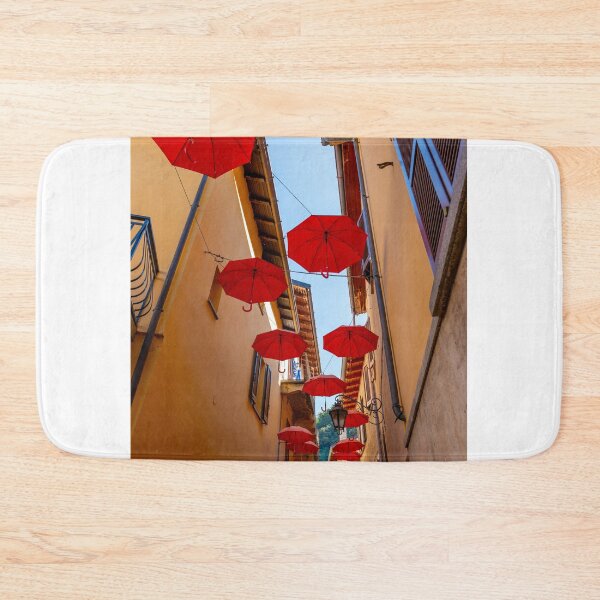 Item preview, City Street in Porto Ceresio with Hanging Umbrellas in a Sunny Summer Day designed and sold by Mats Silvan.