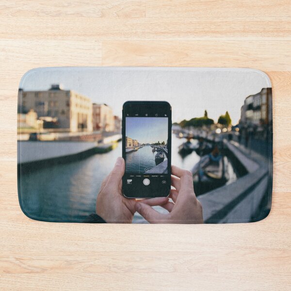 Item preview, Hand holding a phone taking a picture of a canal. Ria de Aveiro, Portugal designed and sold by João Miguel.