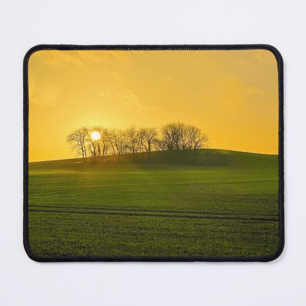 Item preview, Sun setting behind bare trees on a green hill designed and sold by Michael Brewer.
