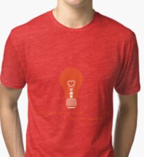 Glowing light bulb with glower in shape of heart. Tri-blend T-Shirt