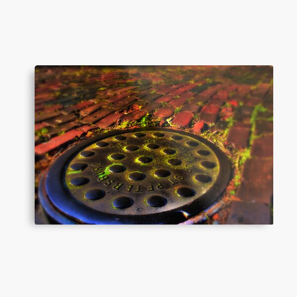Manhole Cover on Red Brick Road Metal Print