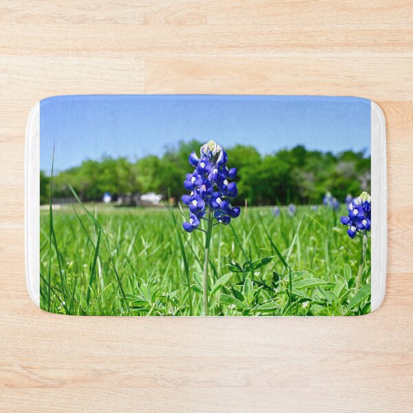 Item preview, Bluebonnet flower blooming in a field with trees behind it designed and sold by Stretch Clendennen.