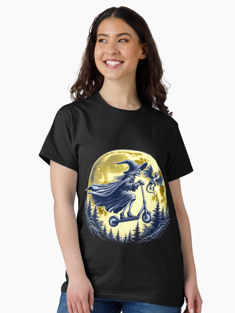 Thumbnail 2 von 7, Classic T-Shirt, Hexe mit einem Tretroller ohne Besen ist fliegend vor einem Vollmond. designt und verkauft von Matzi-MV.