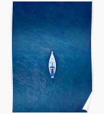 A drone shot of a sailing boat surrounded by deep blue sea water Poster