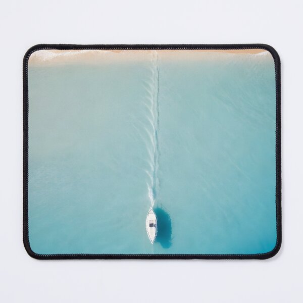 Item preview, A boat moving through clear blue waters near a sandy beach creating a trail in the water designed and sold by islamicwallart.