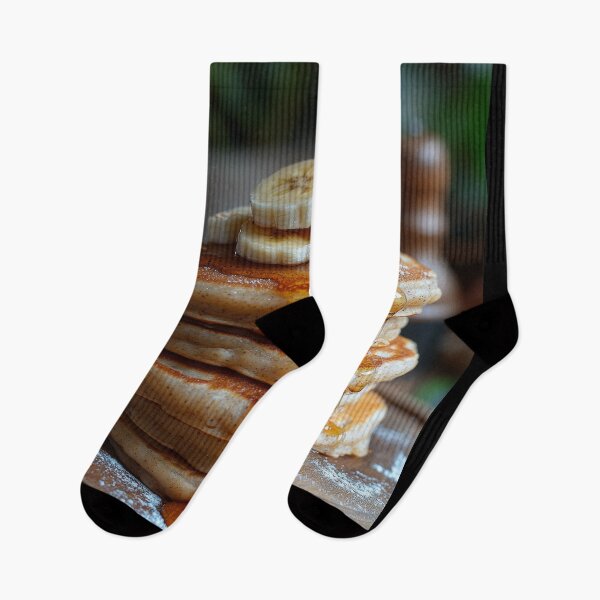Item preview, A delicious stack of banana pancakes topped with syrup on a wooden plate, set against a warm, softly lit background. designed and sold by Jerhus.