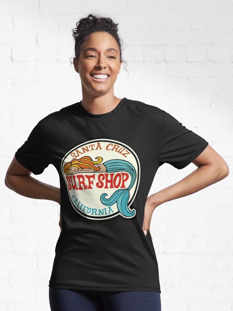 Aperçu 6 sur 7. T-shirt respirant avec l'œuvre Santa Cruz Surf Shop - Autocollant avec logo de sirène de surf vintage de Californie créée et vendue par Kludoman.