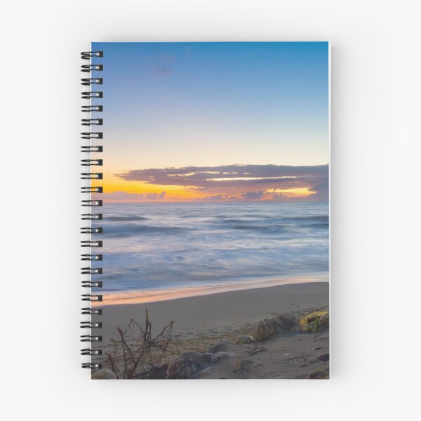Item preview, Waves gently crash on a sandy beach as the sun rises, casting vibrant hues across the sky designed and sold by EyezWatchin.