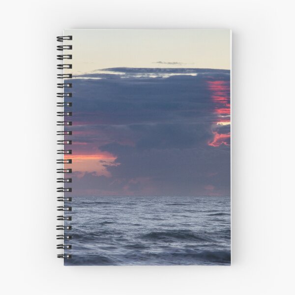Item preview, Dark clouds stretch across the horizon during a sunrise over the ocean, with hints of vibrant red and orange designed and sold by EyezWatchin.