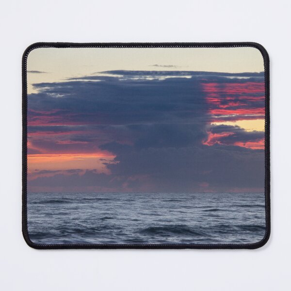 Item preview, Dark clouds stretch across the horizon during a sunrise over the ocean, with hints of vibrant red and orange designed and sold by EyezWatchin.