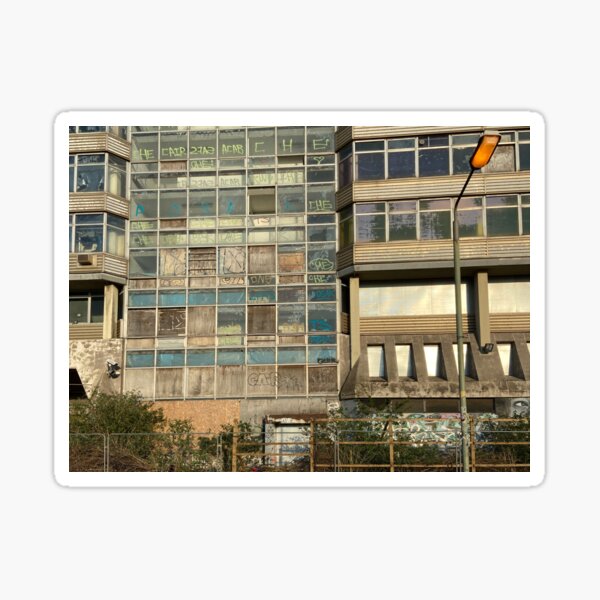 faded, boarded up, glowing orange bulb hangs heavy in the foreground Sticker