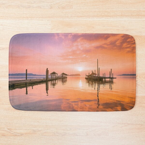 Item preview, Tranquil sunrise over a wooden pier and hut on calm water designed and sold by homydesign.